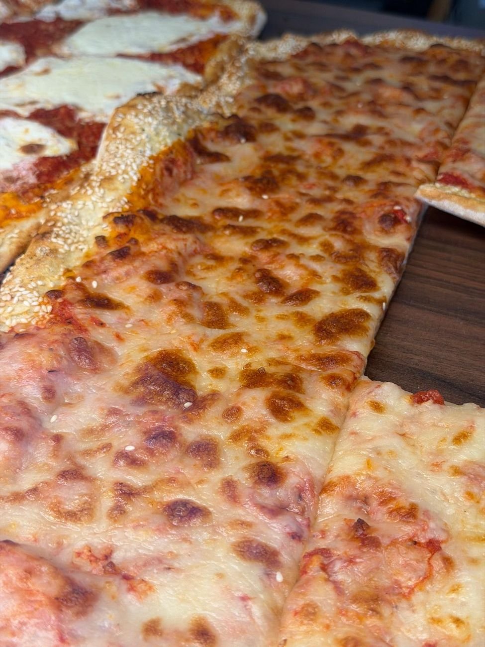 A close view of a margherita slice, crisp at the edge